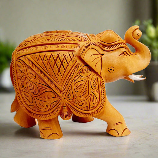 Handcrafted wooden saluting elephant idol made from Kadamba wood with ball in trunk.