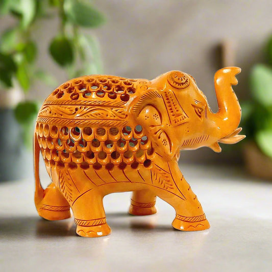A beautiful wooden carved elephant with an undercut design showing a baby elephant inside.