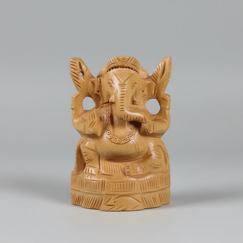 Frontal view of a 10cm hand-carved natural wood Ganpati idol with a traditional crown and detailed trunk, showing a matte unpainted finish.
