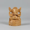 Frontal view of a 10cm hand-carved natural wood Ganpati idol with a traditional crown and detailed trunk, showing a matte unpainted finish.
