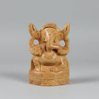 Frontal view of a 10cm hand-carved natural wood Ganpati idol with a traditional crown and detailed trunk, showing a matte unpainted finish.