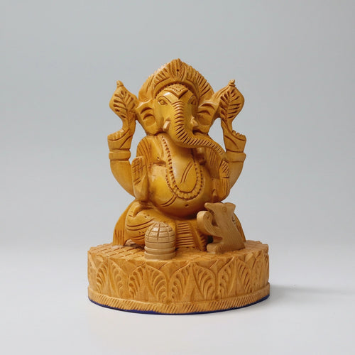 Front view of a 13cm compact wooden Ganesha statue showing the hand-carved crown and trunk on natural timber.