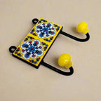 A two-hook Blue Pottery wall art piece, perfect for hanging towels in a bathroom.