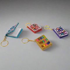 Handcrafted diary-shaped keyring made from lac with mirrors and beads.