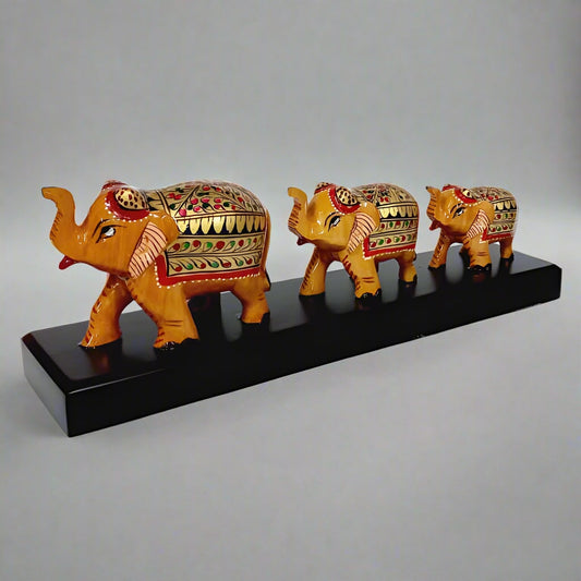 Decorative wooden bridge with small, medium, and large elephants, showcasing artisanal hand-painting