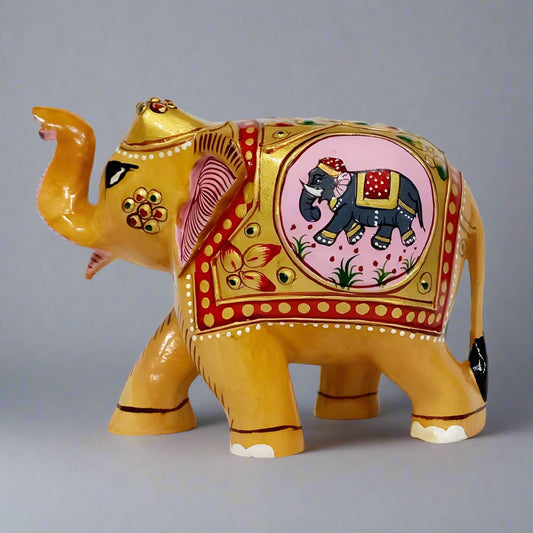 Kadamb wood carved elephant with detailed embossed artwork and trunk raised symbolizing good luck and prosperity, measuring 10cm tall.