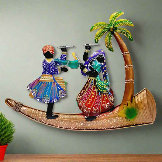 Dancing Couple with Shehnai Metal Wall Art – Hand-painted metal artwork featuring a vibrant couple performing dandiya, set beside a beautifully crafted tree, all mounted on a large decorative shehnai.