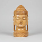 Frontal view of a 20cm hand-carved Kadamba wood Buddha head showing symmetrical facial features and a polished natural grain finish.