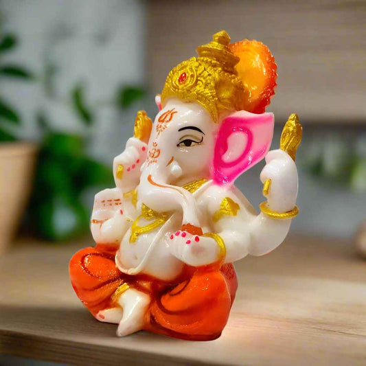 Handcrafted white Lord Ganesha idol in a calm pose, featuring detailed gold embellishments for a divine look.