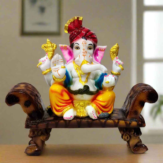 Unique resin Ganesha idol seated on a colorful designer sofa, hand-painted with vibrant traditional detailing.