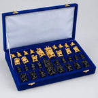 Natural wood-toned and black Ambabari chess pieces arranged in a blue-lined storage box with a velvet box
