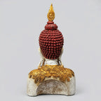 Rear view of resin Buddha bust showing maroon sculpted curls, a gold-tone flame finial and patterned shoulder decoration