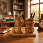 Wooden Ashok Pillar with Indian tricolour and carved pen stand holding two pens on a study desk beside a notebook and clock