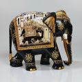 Closeup of miniature painting on black elephant figurine with golden and white detailing