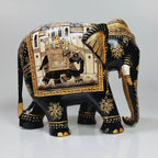 Closeup of miniature painting on black elephant figurine with golden and white detailing
