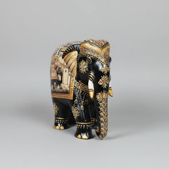 Wooden handcrafted black elephant figurine side angle showing golden highlights