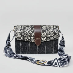 Women’s black and white floral sling bag with a textured woven fabric body and premium black PU leather accents.