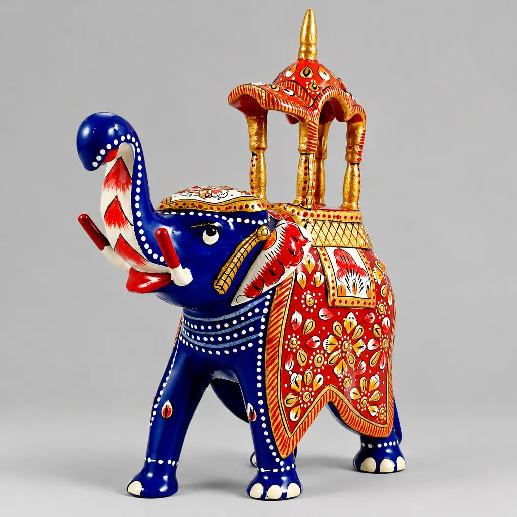 Front angled view of a blue Meenakari Ambabari elephant with a raised trunk, red floral saddle and orange-gold canopy.