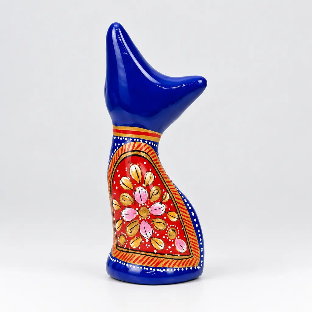 Back view of blue metal meenakari cat statue with a red panel and pink and gold floral detailing
