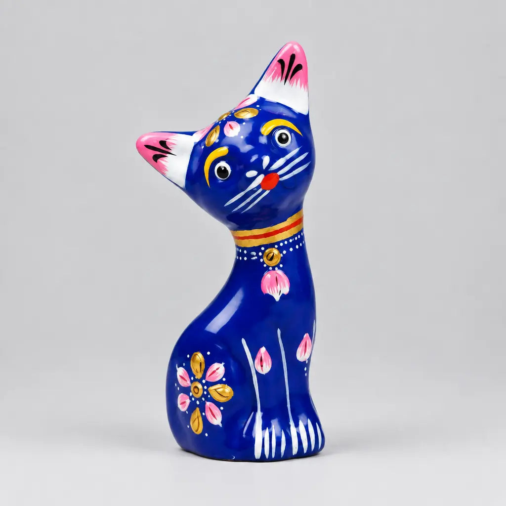 Front view of blue metal meenakari cat statue with pink ears, white whiskers and floral patterns