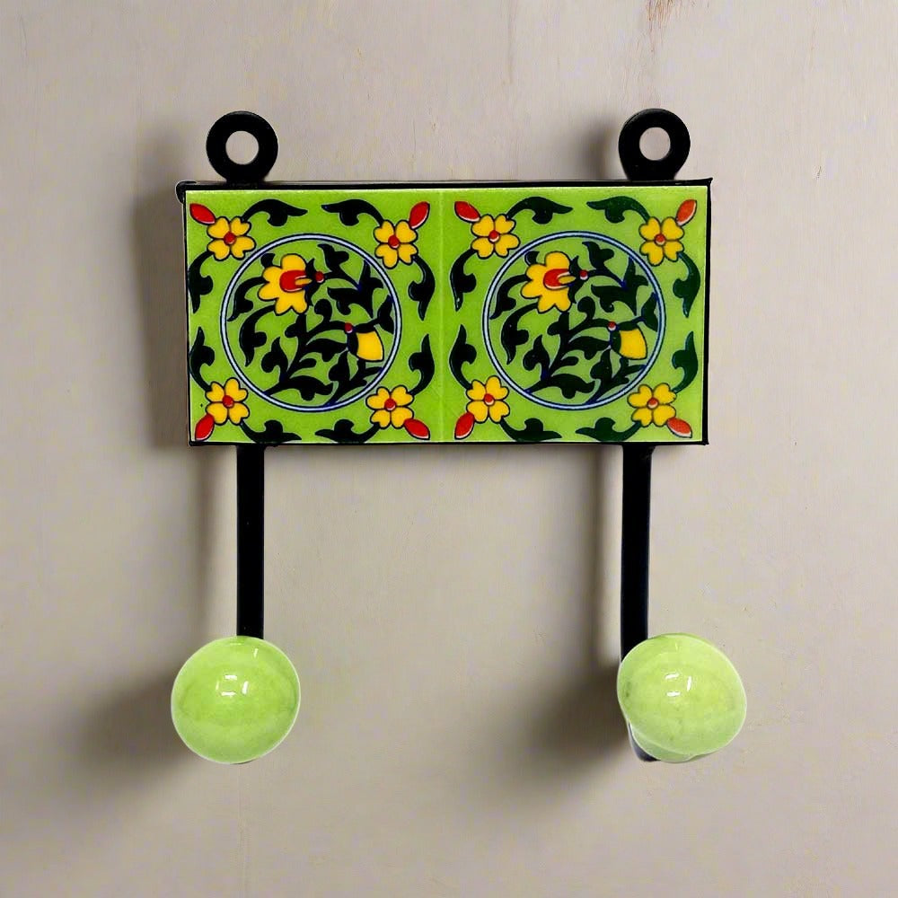 A decorative Blue Pottery cloth hanger with two hooks for wall mounting.