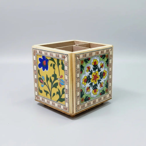 Close-up of Blue Pottery floral tile on revolving pen holder, vibrant assorted colors