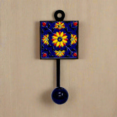 A decorative Blue Pottery wall hook that can be used as a cloth hanger.