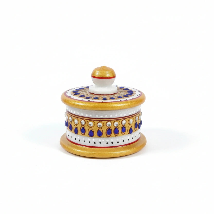 Close-up of blue and white stones studded on a white marble pooja box.