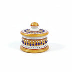 Close-up of blue and white stones studded on a white marble pooja box.