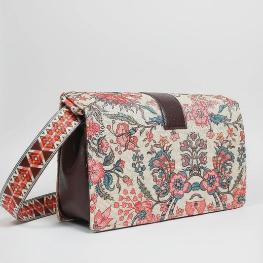 The side profile of the woven handbag highlighting the adjustable sling made from matching floral fabric.