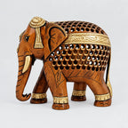 Brown and gold wooden elephant with intricate jaali carving, gold tusks and a downward trunk, viewed from the front angle