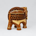 Rear angled view of a brown wooden elephant with carved jaali openings, gold painted details and a long tail