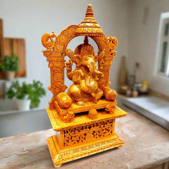 A carved wood Ganesh figurine featuring a lattice arch design and peacocks on the pillars.