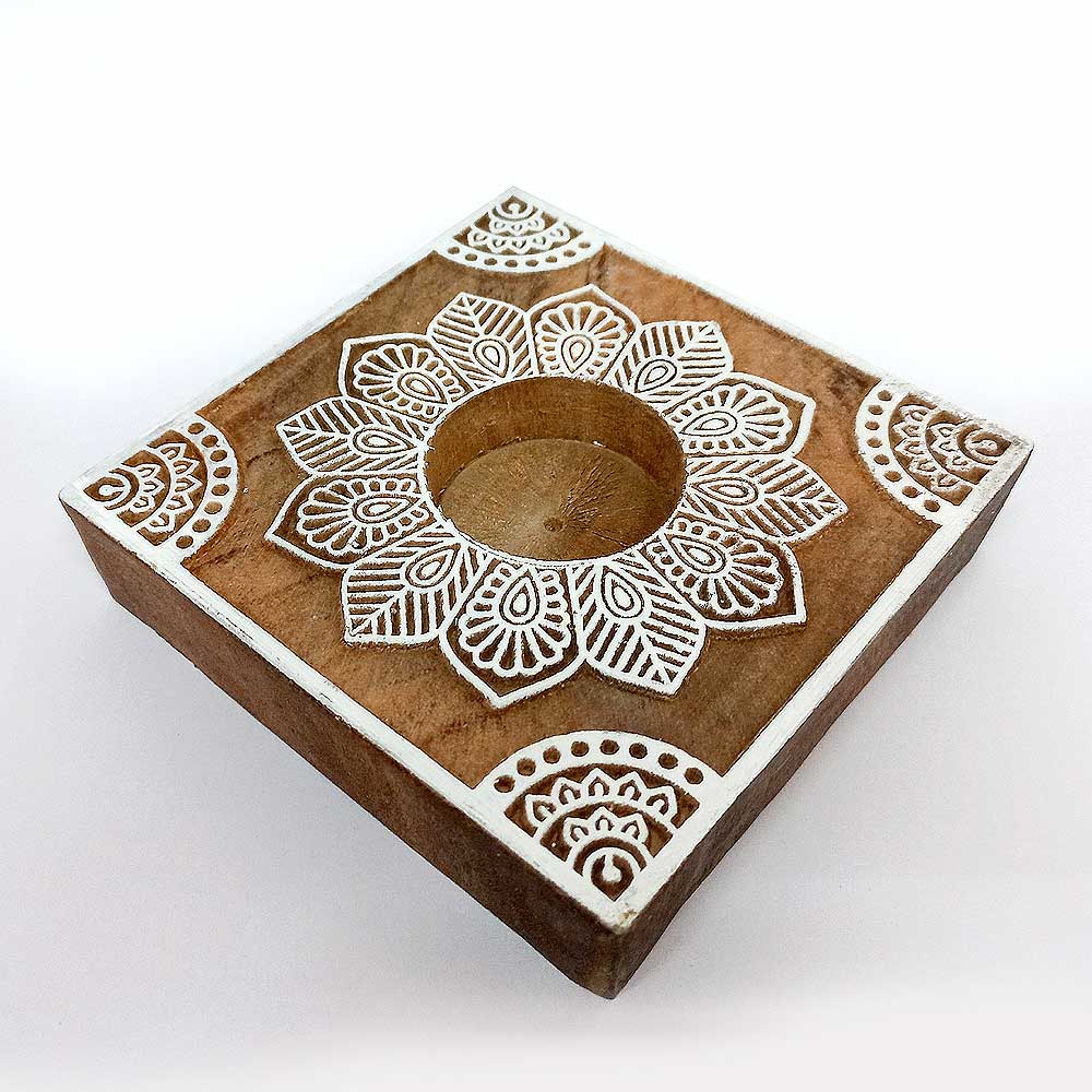 A carved wooden candle holder, a stylish addition to a living room or bedroom.