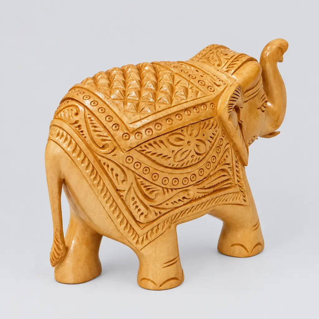 Side view of carved wooden elephant statue with raised trunk