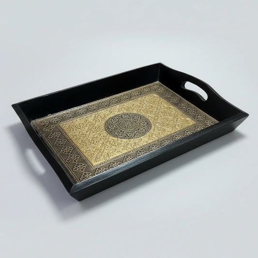 Close up of the intricate embossed floral design on the golden and copper metal sheet inside the wooden tray.