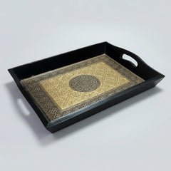 Close up of the intricate embossed floral design on the golden and copper metal sheet inside the wooden tray.