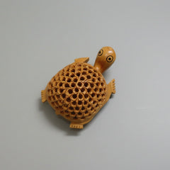 Close up of the delicate lattice and undercut carving work on the wooden tortoise statue.