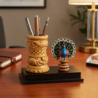 Wooden pen stand with carved bird motifs, lattice cutwork and a blue peacock with spread feathers on a black platform