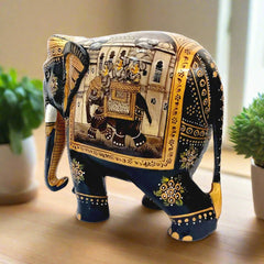 A decorative black elephant statue featuring miniature art on its body.