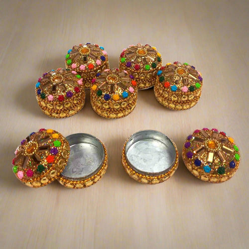 A decorative kumkum box with a hand-painted design for religious use.