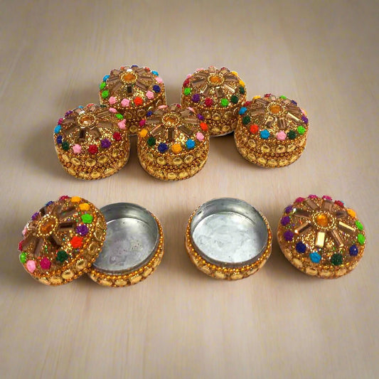 A decorative kumkum box with a hand-painted design for religious use.