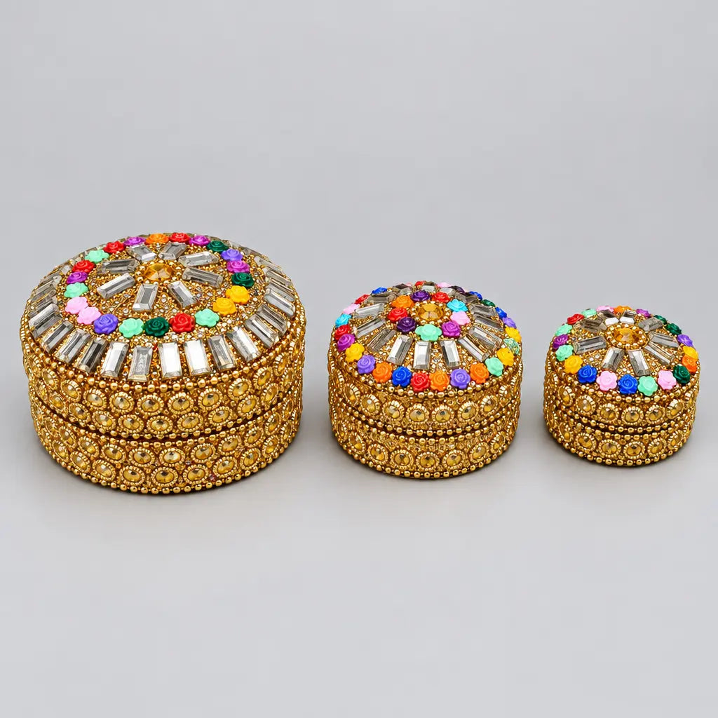 Three round decorative lac boxes in different sizes with golden detailing, colourful flower accents and reflective lid decorations.