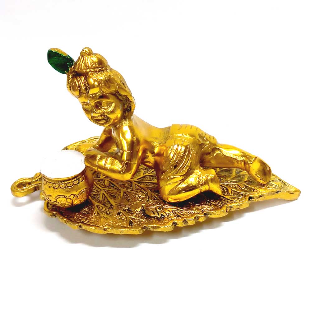 Decorative Laddu Gopal idol sitting on leaf, perfect for home decor and worship.