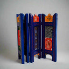 Compact wooden screen with artisan-crafted emboss and hand-painted finish, placed as a backdrop for event decoration.