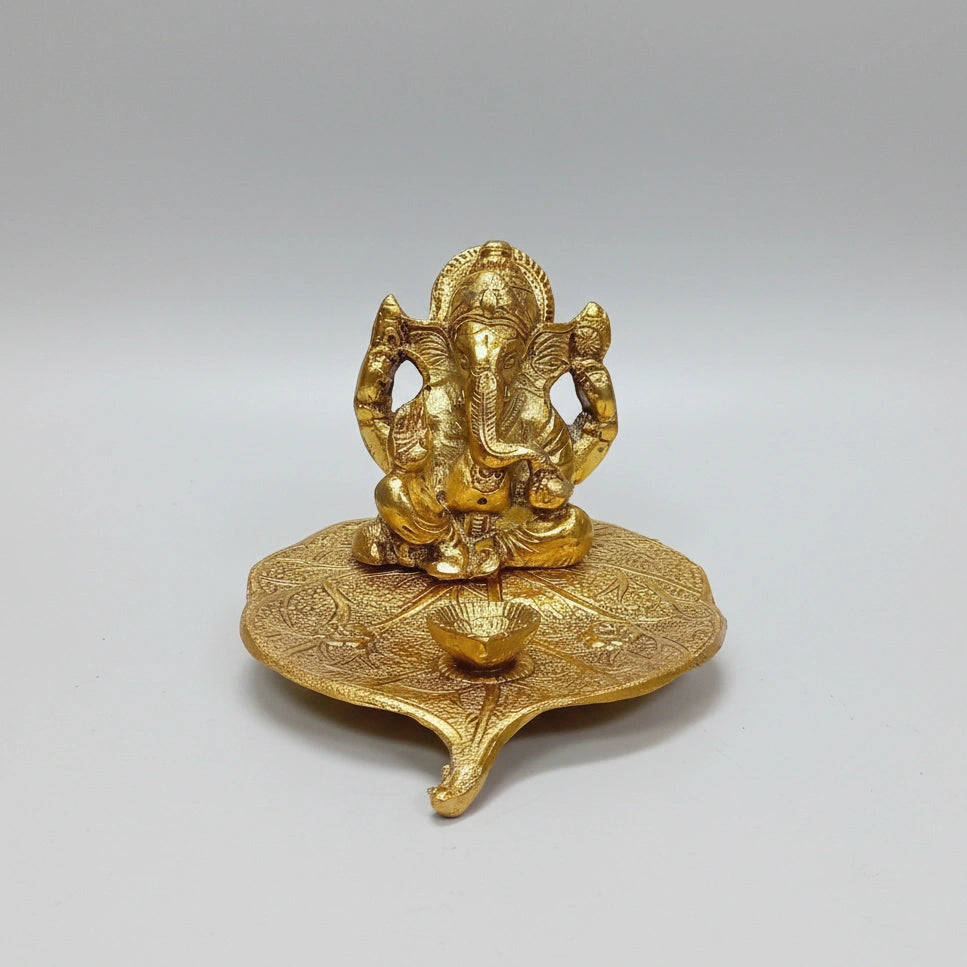 Close-up view of the intricate leaf textures and Lord Ganesha's features in a long-lasting golden polish.