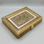 Angled view of gold-tone wooden dry fruit box with two elephant motifs, an ivory-tone border and front clasp