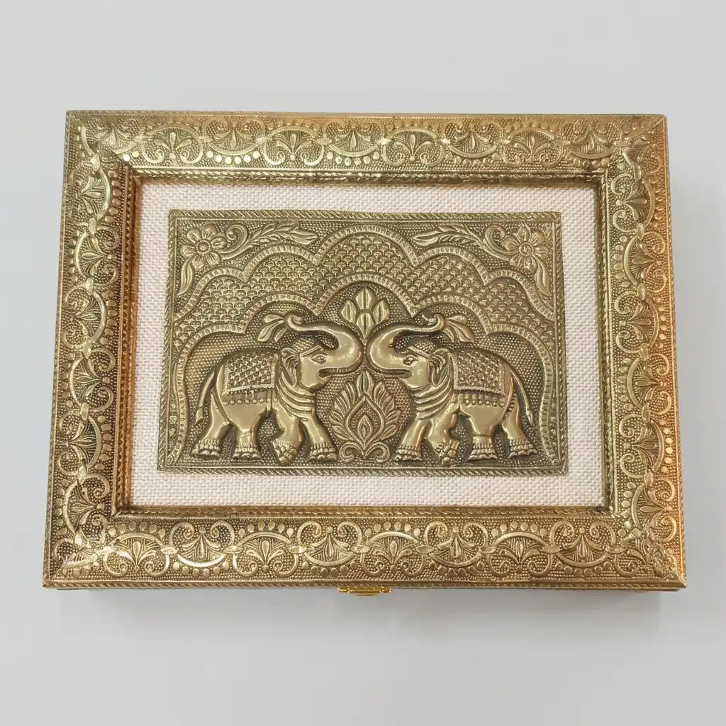 Top view of dry fruit box lid featuring two facing elephants, decorative arches and an ornate gold-tone floral border