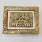 Top view of dry fruit box lid featuring two facing elephants, decorative arches and an ornate gold-tone floral border