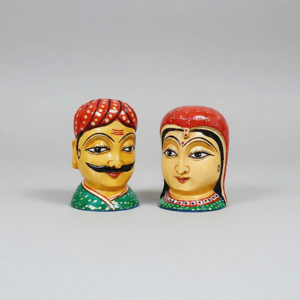 Wooden Rajasthani couple figurines placed on a shelf as ethnic home decor.